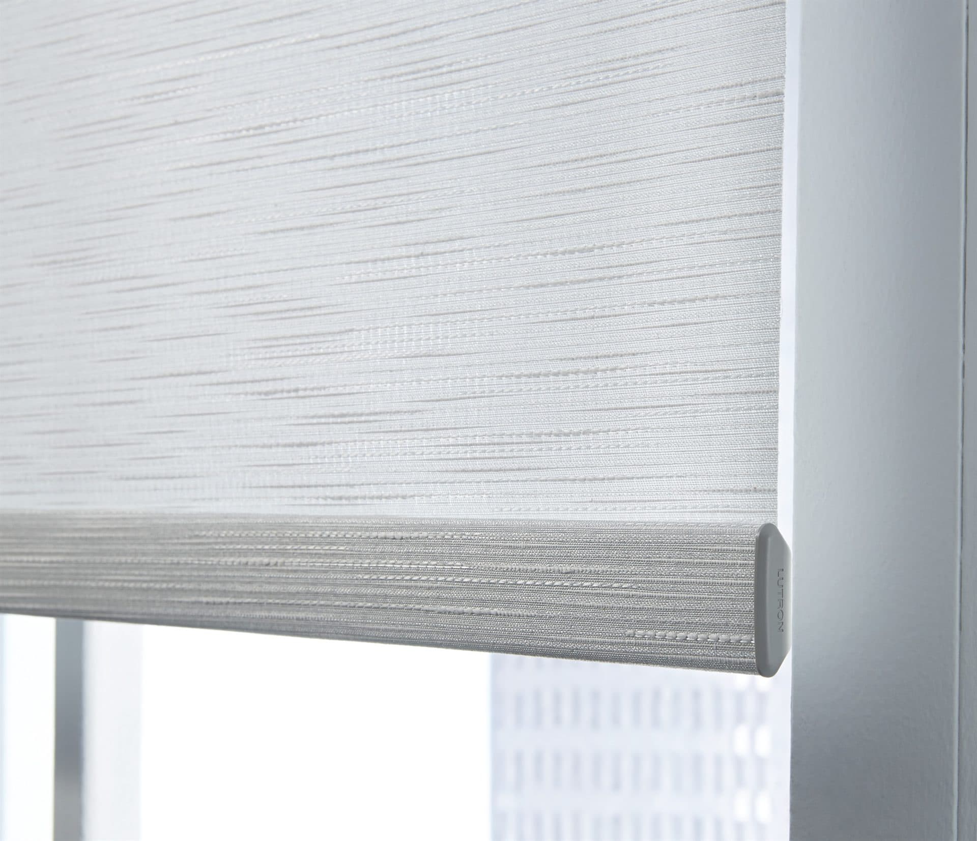 A close detail of a woven roller-blind fabric and slim hembar