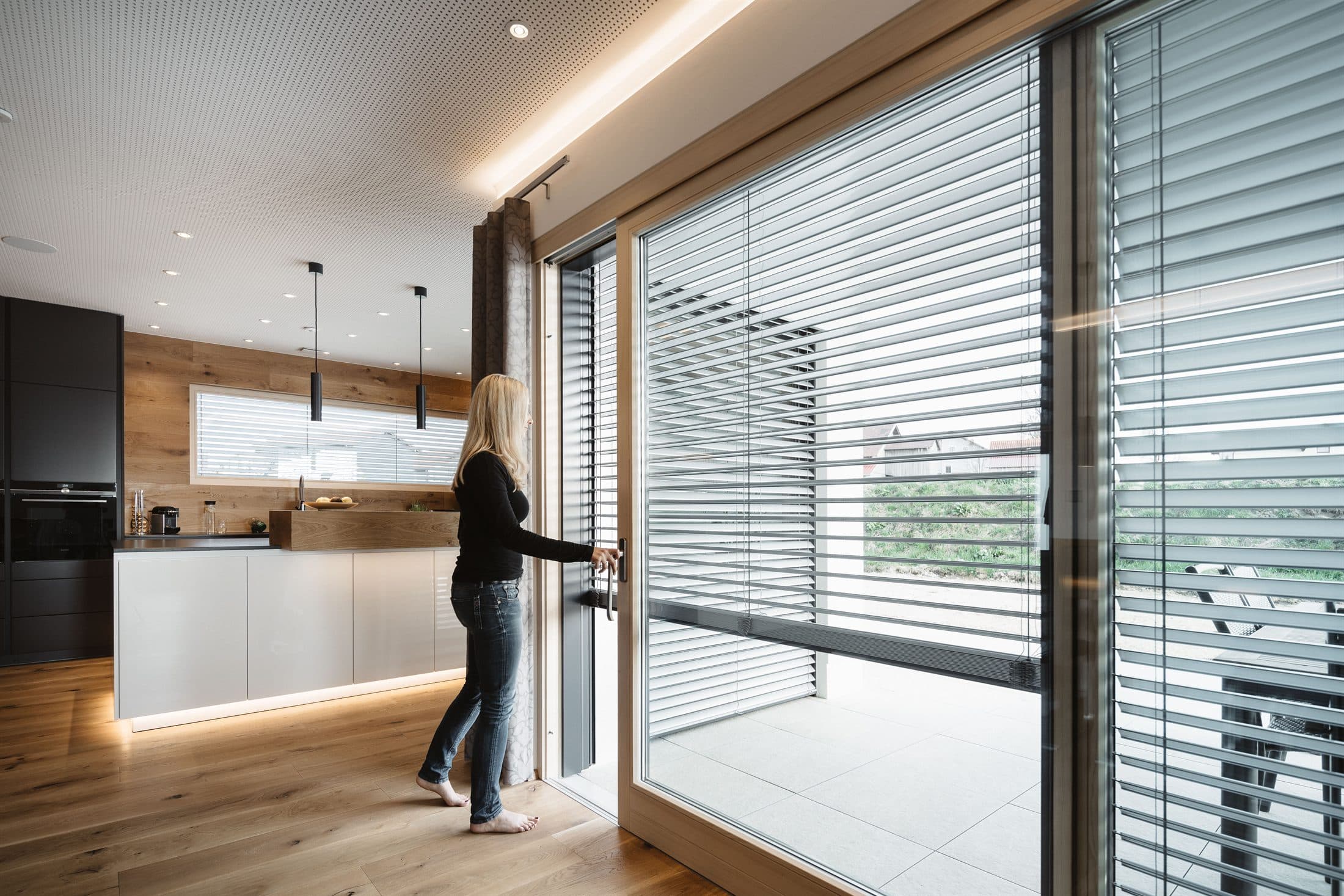 Automated external blinds shading a modern kitchen with a glazed balcony door