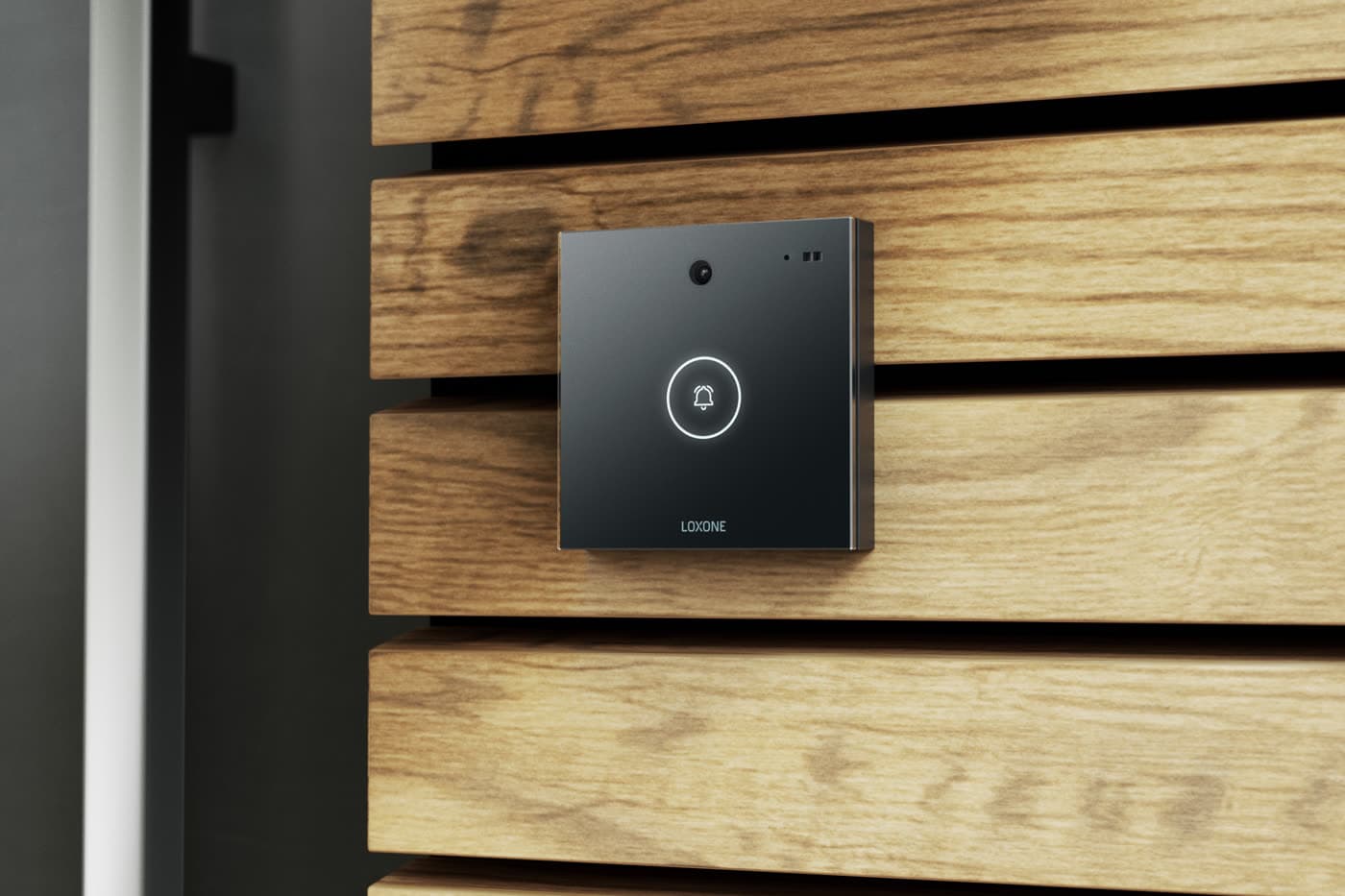 A black glass video intercom with a built-in camera mounted on a slatted timber wall