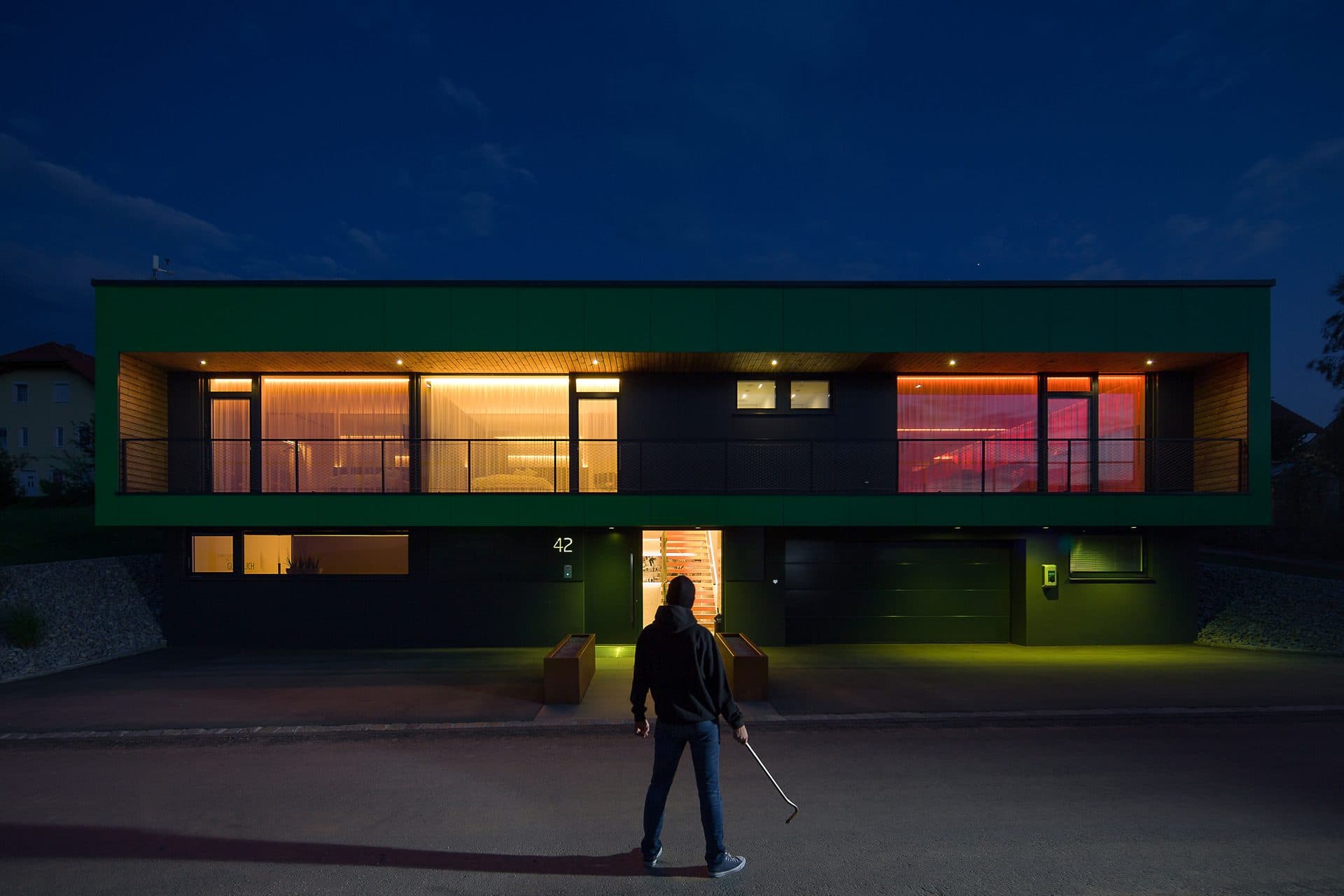 A contemporary home at dusk, lit by integrated lighting